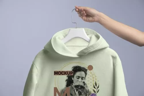 دانلود فایل PSD نمای نزدیک دست در حال نگه داشتن چوب لباسی با هودی 24760