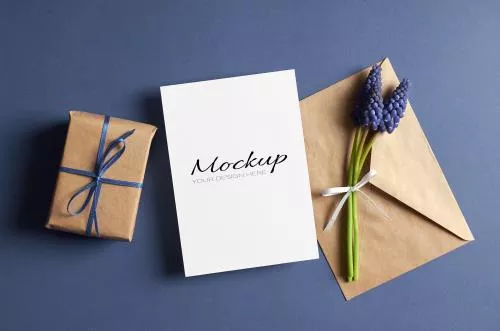 موکاپ دعوت نامه یا کارت تبریک با پاکت و جعبه هدیه و گل های آبی فایل PSD لایه باز 21006