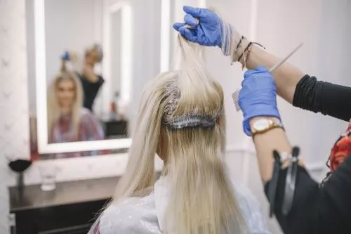 عکس با کیفیت مناسب برای آرایشگاه های زنانه شامل خانمی درحال رنگ کردن مو مشتری از زاویه پشت 21049
