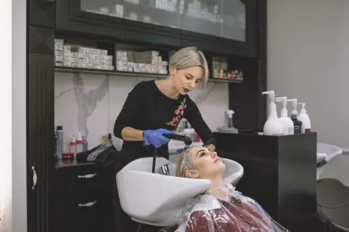 عکس با کیفیت مناسب برای آرایشگاه های زنانه شامل خانمی درحال رنگ کردن مو مشتری و شستن از زاویه روبرو 21050