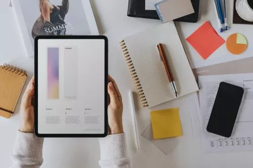 موکاپ تبلت و موبایل روی میز به همراه دفتر و خودکار در دست خانم فایل PSD لایه باز 22049