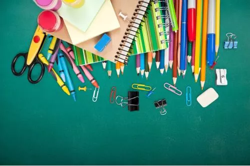 عکس JPG باکیفیت از تخته سیاه مدرسه و لوازم تحریر شامل مدادرنگی و قیچی و دفتر و تراش و گیره و ماژیک 22132