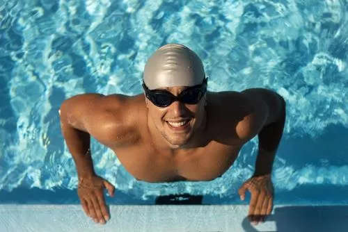 عکس شناگر مرد خندان با عینک و کلاه در استخر 21670